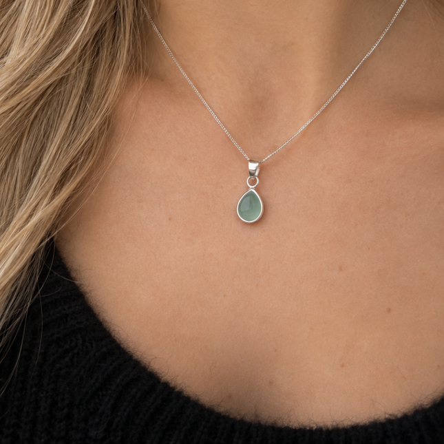 een subtiele zilveren ketting met een druppelvormige hanger van aquamarijn