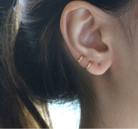  Kleine goudkleurige oorringen en een oorknopje, gedragen in meerdere gaatjes.
8mm