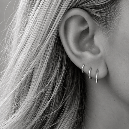Een set van drie paar dunne, gladde oorringen in echt 925 zilver: 8, 10 en 12 mm. Samen vormen ze een rustig set in oplopende maat langs je oorlel, maar je kunt ze ook los dragen of combineren met je eigen favorieten. Zo licht dat je ze dag en nacht in kunt houden.