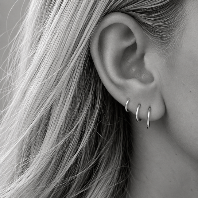 Een set van drie paar dunne, gladde oorringen in echt 925 zilver: 8, 10 en 12 mm. Samen vormen ze een rustig set in oplopende maat langs je oorlel, maar je kunt ze ook los dragen of combineren met je eigen favorieten. Zo licht dat je ze dag en nacht in kunt houden.